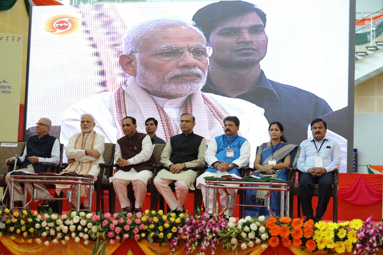 Prime Minister Narendra Modi seated with dignitaries at the Vadodara airport inauguration ceremony